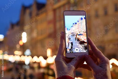 Person is taking photo of christmas illumination with a smartphone. Hands with phone close up - Image