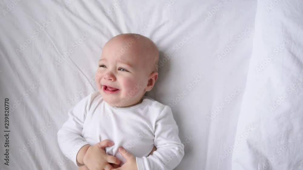 cute four month old baby wrapped into towels after shower in bed at home cute four month old baby wrapped into towels after shower in bed at home
