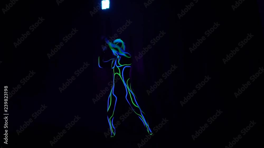 Neon performance, a man in glowing suit spinning colorful lights Neon performance, a man in glowing suit spinning colorful lights