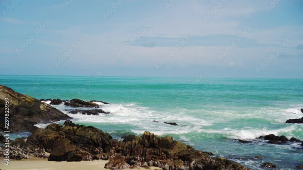 Tropical beach wave and sand and rocks with summer blue sky. Tropical beach wave and sand and rocks with summer blue sky.