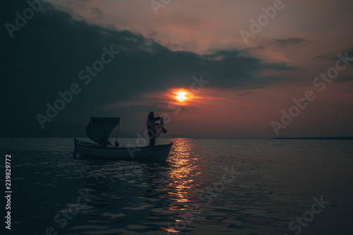 Fisherman collects fish in sunset
