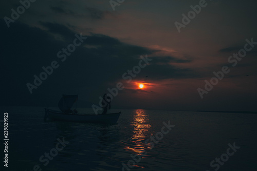 Fisherman tries to collect fishes in sunset