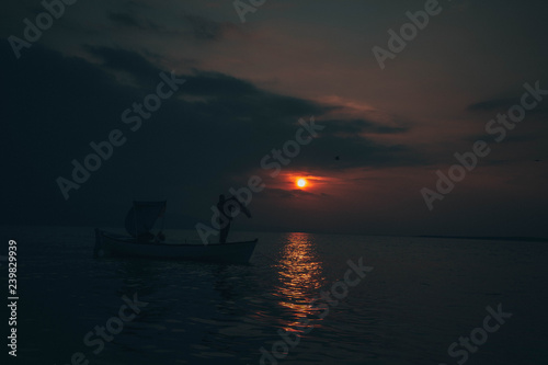Fisherman tries to collect fishes in sunset