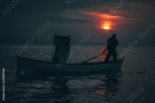 Sun goes down while fisherman throws his fishnet to collect fishes