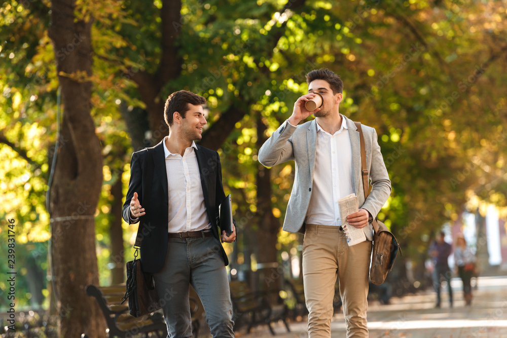 Two happy businessmen walking outdoors Two happy businessmen walking outdoors
