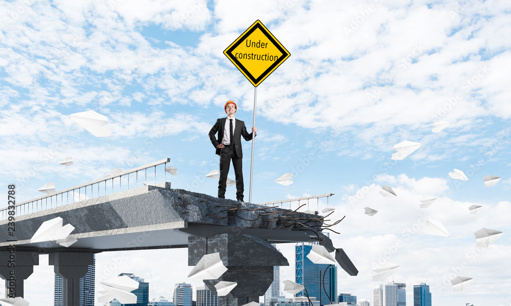 Confident engineer holding street safety sign. Confident engineer holding street safety sign.