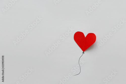 Valentines day card. Red paper heart shape balloons on thread. Paper cut style and minimalist concept