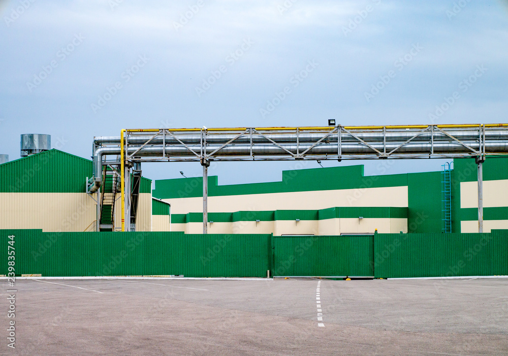 The road leading to the warehouse of the factory. Green and white front. Industrial concept The road leading to the warehouse of the factory. Green and white front. Industrial concept