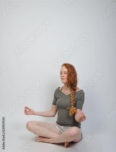 frau rothaarig schlank beim meditieren yoga pilatis entspannen photo
