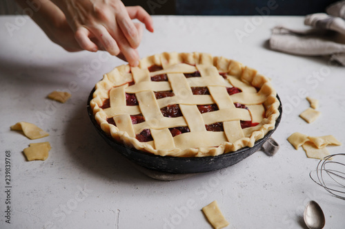 Uncooked berry pie with a lattice decoration on top. Concrete background, cooking process.