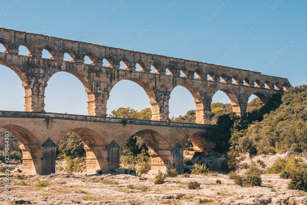 The view from the banks of the river Gardon on the arched stone bridge of Pont du Gard - perspective