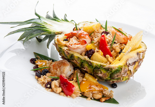 Cut pineapple stuffed with rice and Royal shrimps. On white background photo