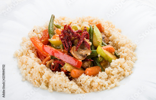 Wok vegetables in coconut milk with couscous. Vegetarian dish. On white background