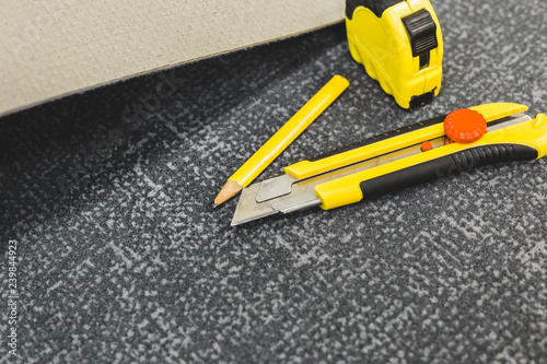 Work tools for laying carpet - tape measure, knife and pencil - laying flooring