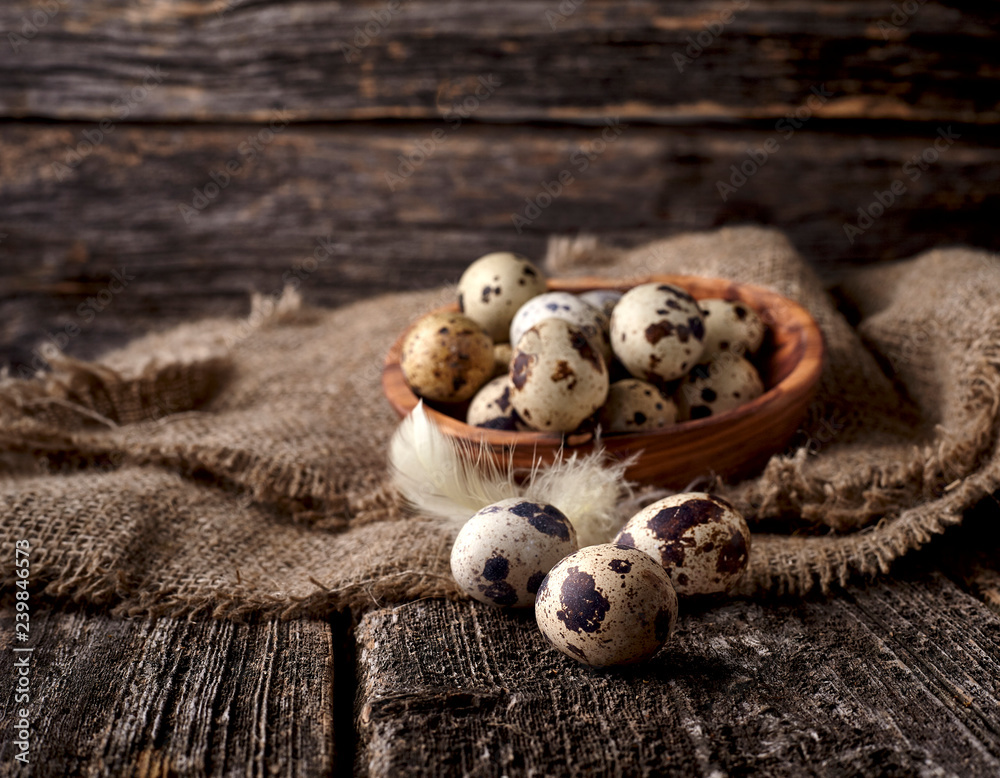 Quail eggs in a wooden plate on the old background. Rustic style on dark wood background. Quail eggs in a wooden plate on the old background. Rustic style on dark wood background.