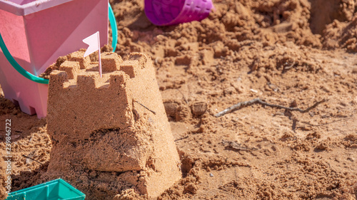 Sand castle surrounded by beach toys