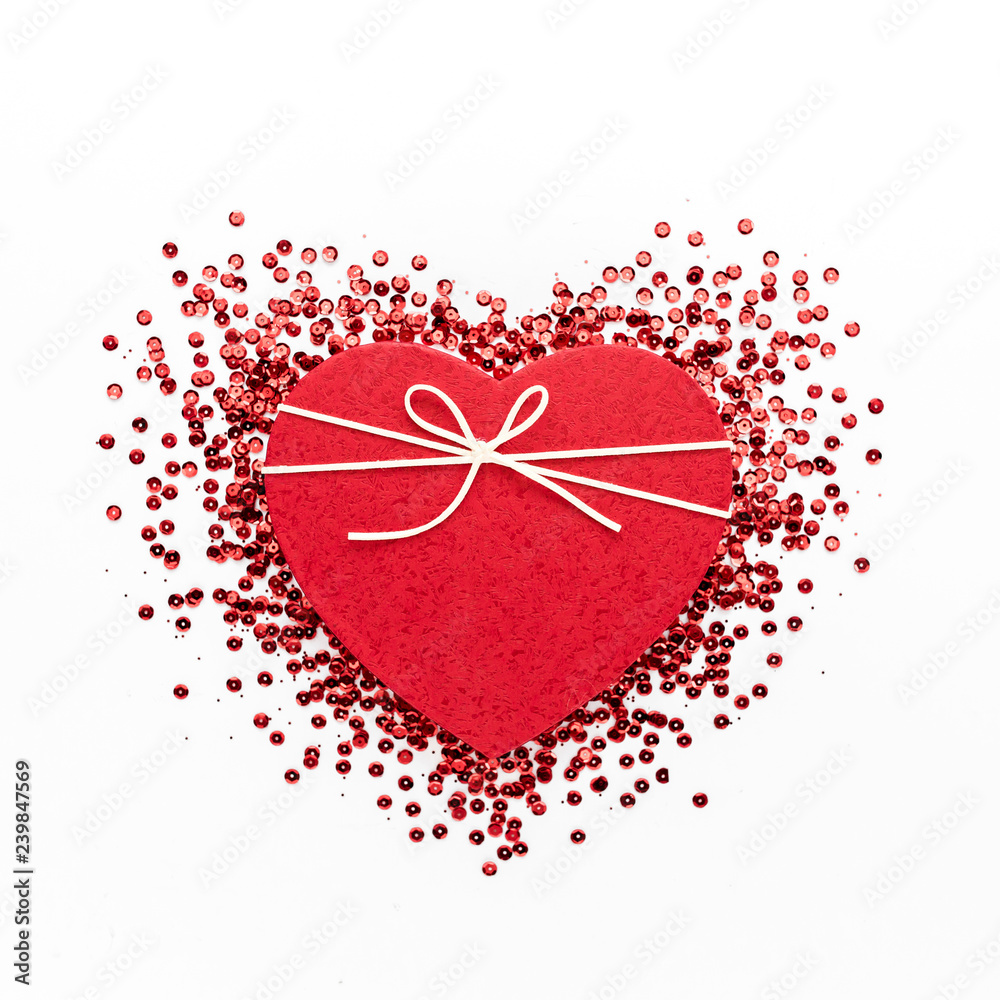 Red heart symbol on white background. Heart of glitter grains. Valentine's Day composition. lay flat, top view Red heart symbol on white background. Heart of glitter grains. Valentine's Day composition. lay flat, top view