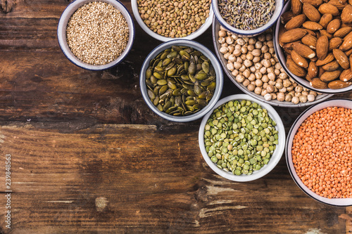 Composition of different types of legumes in bowls on wooden background