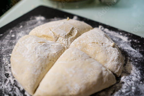 Sliced dough in flour on black breadboard 