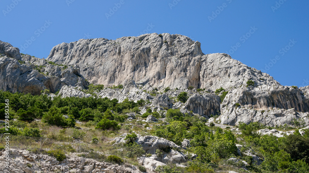Mountain landscape with rugged white limestone cliffs on a sunny summer day, Biokovo mountain range in Croatia. 