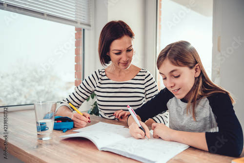Mother helping daughter to finish homework