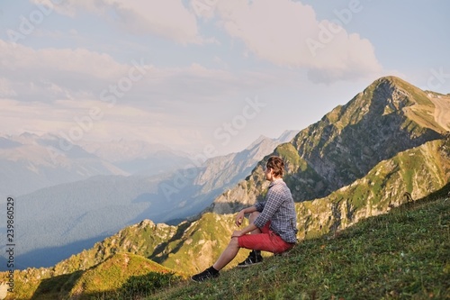 Obraz na płótnie man sits on top of a mountain enjoying the view w salonie