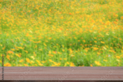 Wooden table with blur yellow flowers field background © BNMK0819