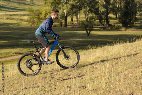 Cyclist in shorts and jersey on a modern carbon hardtail bike with an air suspension fork 