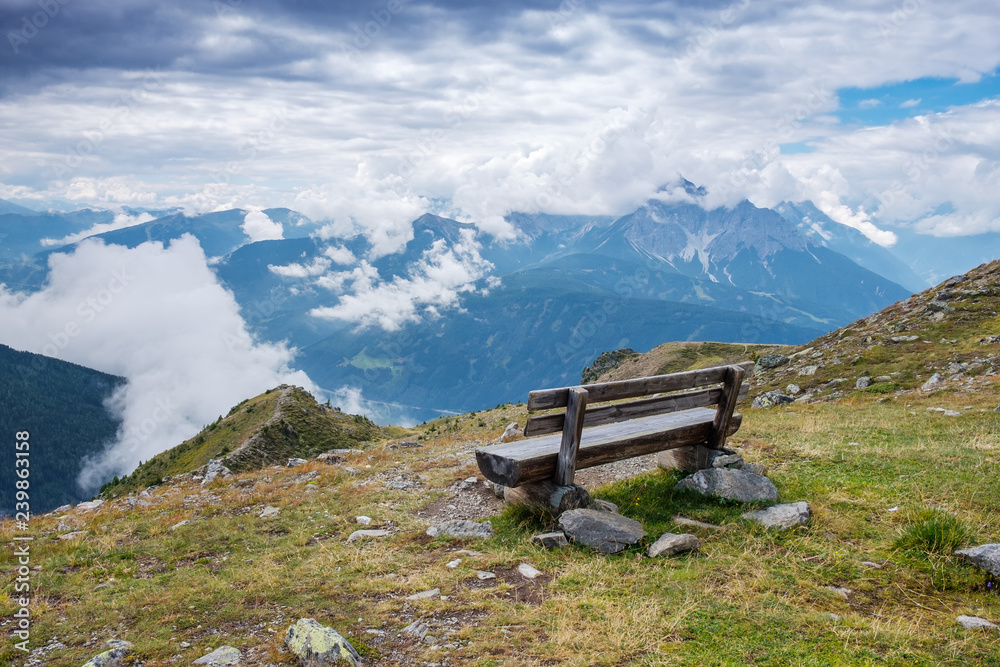 Observation deck with a bench in the Alpine mountains overlooking the valley Observation deck with a bench in the Alpine mountains overlooking the valley