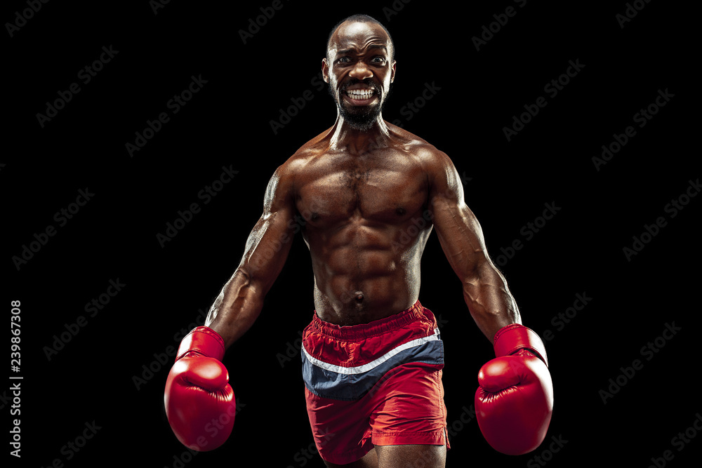 Hands of boxer over black background. Strength, attack and motion concept. Fit african american model in movement. Afro muscular athlete in sport uniform. Sporty man during boxing