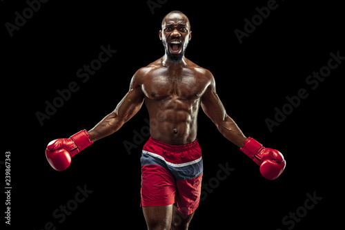 Hands of boxer over black background. Strength, attack and motion concept. Fit african american model in movement. Afro muscular athlete in sport uniform. Sporty man during boxing