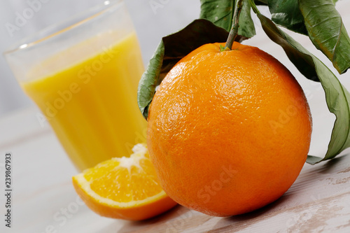 orange and glass of orange juice on white wooden table
