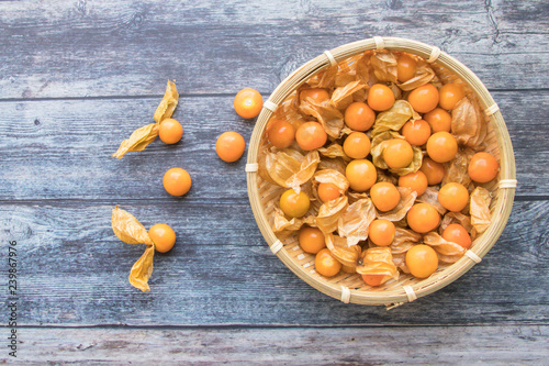 Cape gooseberry fruits in the basket (Physalis peruviana) on wooden background.Commonly called goldenberry, golden berry, Pichuberry. photo