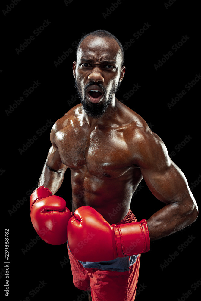 Hands of boxer over black background. Strength, attack and motion concept. Fit african american model in movement. Afro muscular athlete in sport uniform. Sporty man during boxing