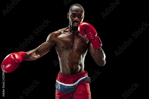 Hands of boxer over black background. Strength, attack and motion concept. Fit african american model in movement. Afro muscular athlete in sport uniform. Sporty man during boxing © master1305