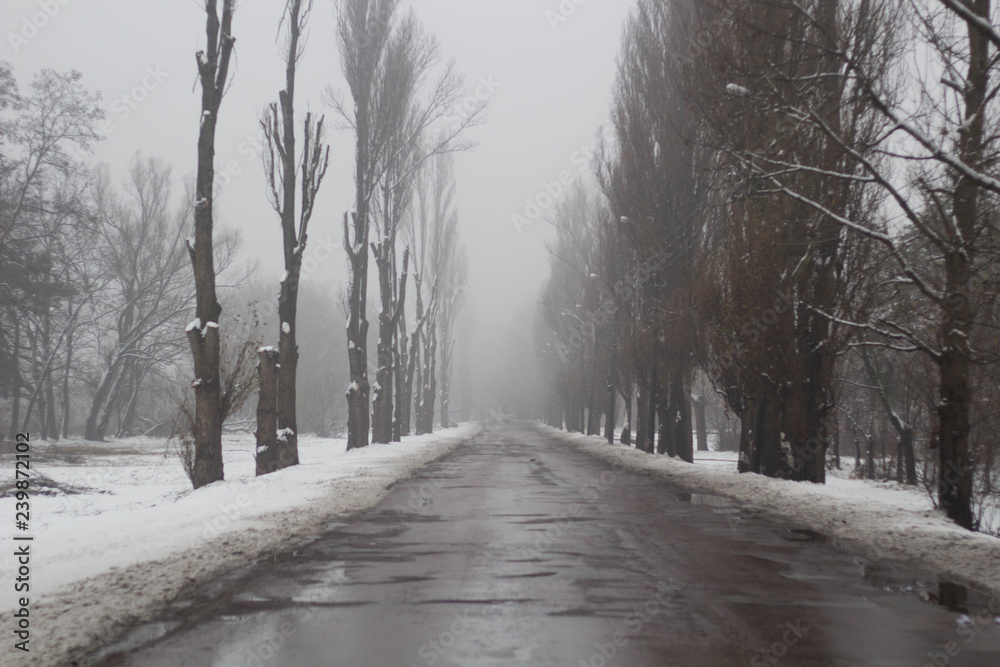 old highway with holes and snow. Landscape road in the potholes in cloudy winter weather. old highway with holes and snow. Landscape road in the potholes in cloudy winter weather.