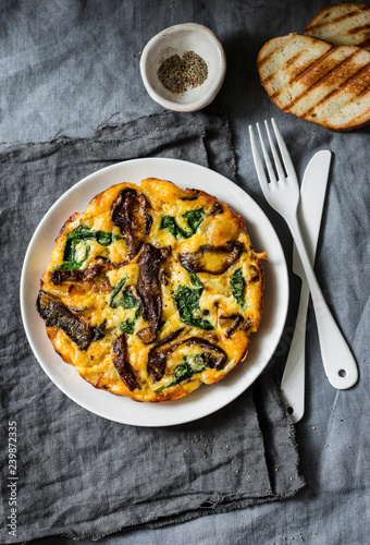 Porcini mushrooms, potatoes, spinach baked frittata - delicious breakfast, snack, tapas on a gray background, top view
