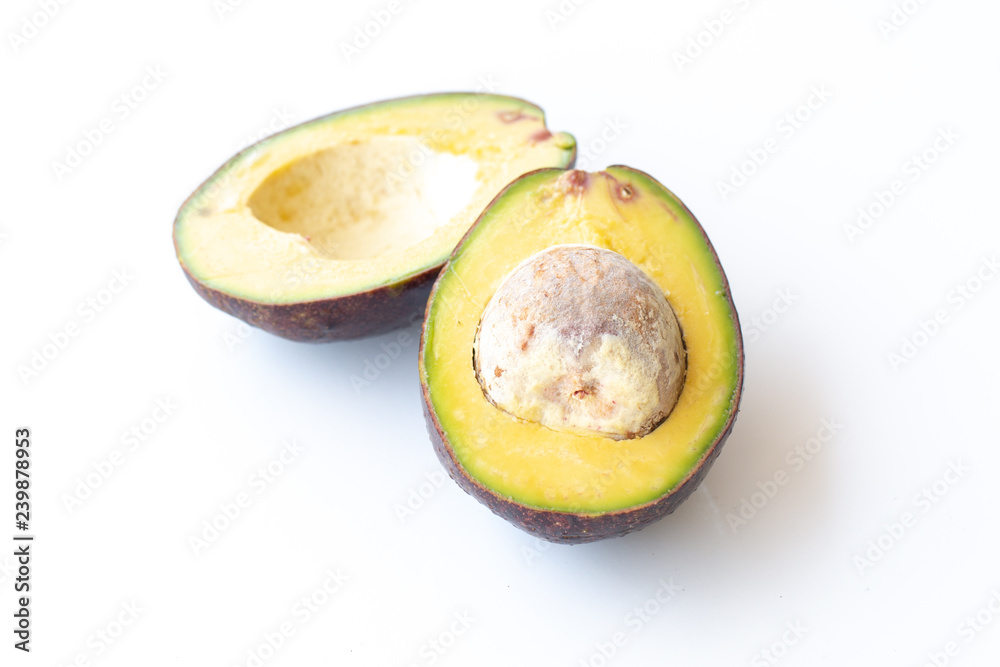 Two slices of avocado on a white background