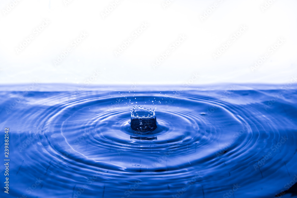 Water drop falling into water making a concentric circles 