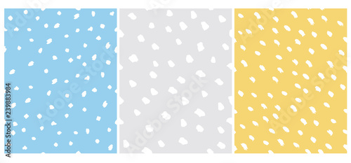 Set of 3 Cute Abstract Dots Vector Pattern. White Irregular Brush Dots on a Gray, Yellow and Blue Backgrounds. Lovely Pastel Color Delicate Layouts. Funny Infantile Style Design.