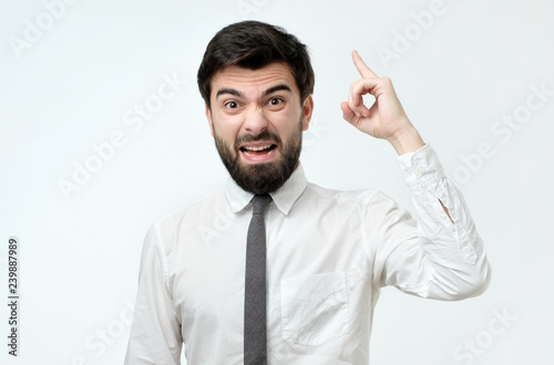 Angry man in ite and white shirt screaming on his coworker photo