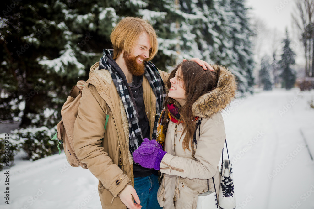 Date of the young couple in the winter. Young Caucasian man with a beard and long hair fooling around kid snow snowballs with a woman, winter games Valentine's Day in the snowy woods Date of the young couple in the winter. Young Caucasian man with a beard and long hair fooling around kid snow snowballs with a woman, winter games Valentine's Day in the snowy woods