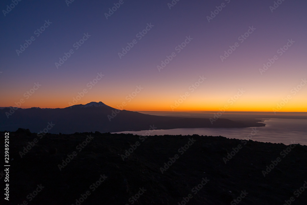 Aerial view with drone from the ski center in the volcano Osorno, Puerto Varas. With Lake Llanquihue and the Calbuco Volcano at sunset 