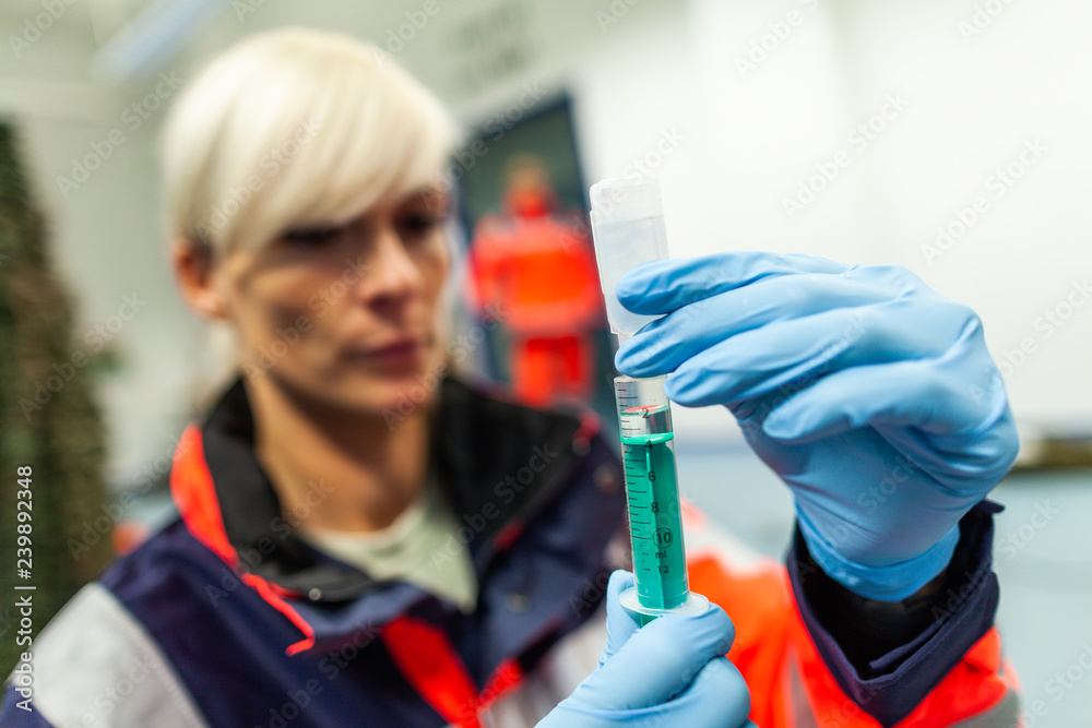 German paramedic picks up a syringe for a patient German paramedic picks up a syringe for a patient