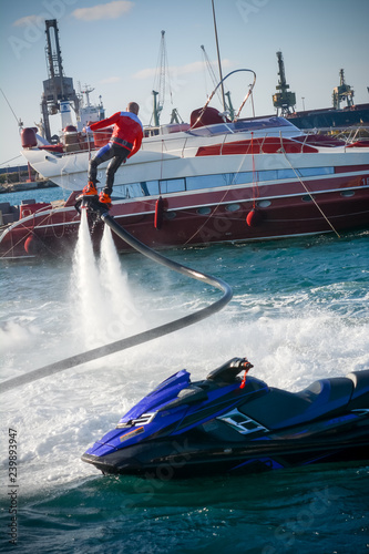 Vertical View of Santa Claus Flying on Flyboard on Blur Background photo