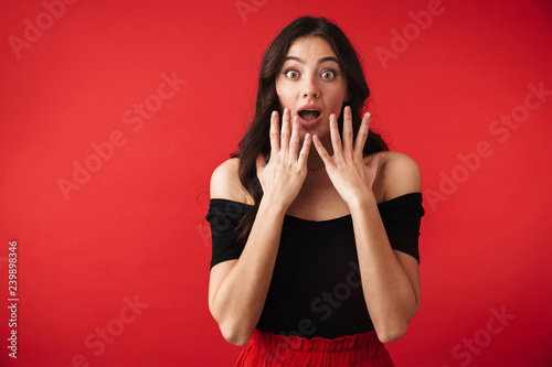 Shocked young woman wearing a dress standing