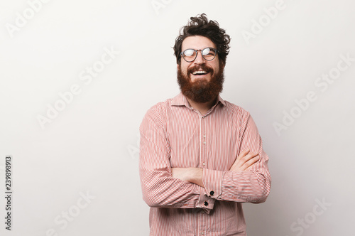 Charming male bearded professor wearing stylish glasses, crossing hands