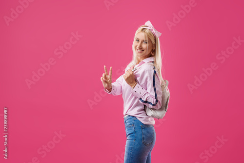 Beautiful and fashionable blond model girl in dress have a fun at pink background