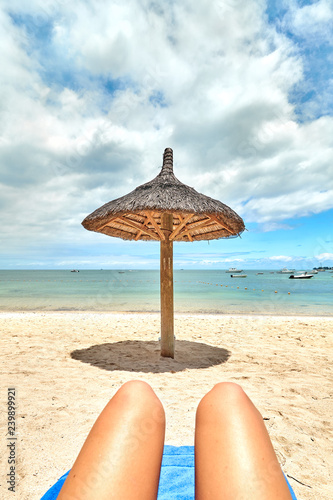 beautiful woman legs resting on the beach sunbathing with the horizon in the background