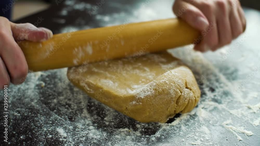 spreading flour on dough and rolling it with rolling pin closeup spreading flour on dough and rolling it with rolling pin closeup